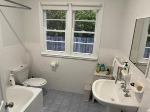 a bathroom with a sink toilet and a window at Moruya Heads Constable Street in Moruya Heads +19 photos