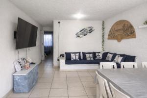a living room with a blue couch and a tv at Departamento en Marina Diamante con lago y alberca in Acapulco