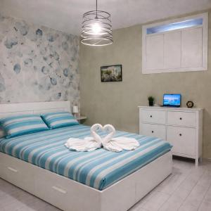 two swans sitting on a bed in a bedroom at Domus Flavia in Pozzuoli