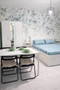 a bedroom with a bed and a table and chairs at Domus Flavia in Pozzuoli