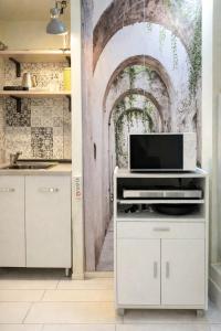 a kitchen with a wall mural of an archway at Domus Flavia in Pozzuoli +2 photos