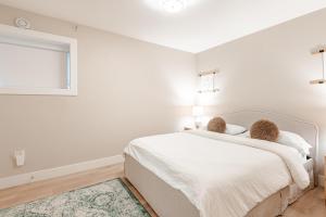 a white bedroom with a bed and a window at Modern Bright Suite Self Check-In in North Vancouver +33 photos
