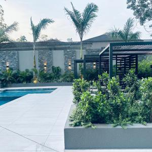 a house with a swimming pool and palm trees at The Bantree by Tripview Apartments in Accra