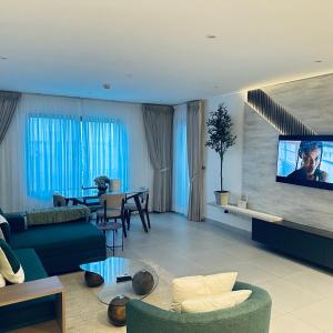 a living room with a couch and a tv on a wall at The Bantree by Tripview Apartments in Accra