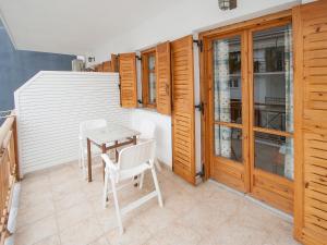a patio with a table and chairs and wooden doors at LAURA Skiathos in Skiathos