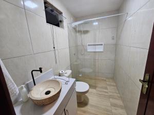 a bathroom with a toilet and a sink and a shower at Suíte Bem Te vi in Porto Seguro +12 photos