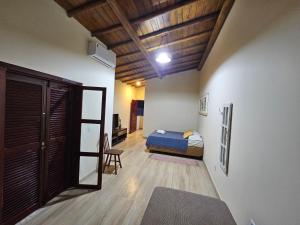 a bedroom with a bed and a chair in a room at Suíte Bem Te vi in Porto Seguro