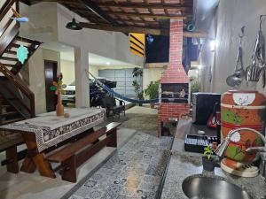 a living room with a fireplace and a hammock at Suíte Bem Te vi in Porto Seguro