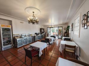 a restaurant with tables and chairs and a kitchen at A Casa Do Caseiro in Funchal +30 photos