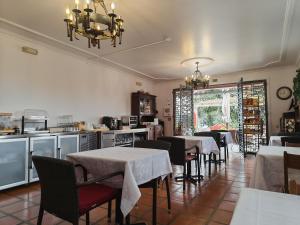 a dining room with tables and chairs and a chandelier at A Casa Do Caseiro in Funchal