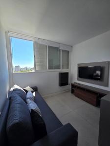 a living room with a blue couch and a flat screen tv at Espacio 43 Terminal in La Plata