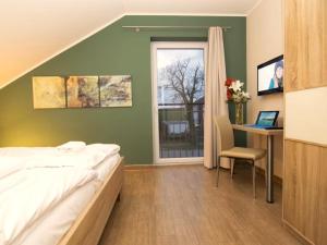 a bedroom with a bed and a desk and a window at Casa Leonardo in Göhren-Lebbin +15 photos