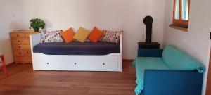 a bedroom with a bed with pillows and a chair at Arya House in Lopar