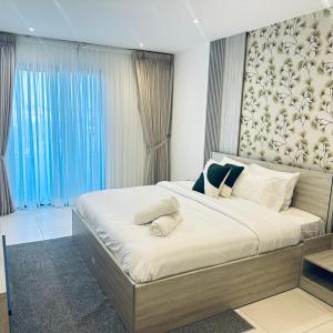 a bedroom with a large bed with white sheets at The Bantree by Tripview Apartments in Accra +38 photos