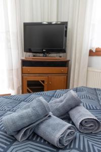 a pile of towels on a bed with a tv at OIKOS SKMT in Sourotí