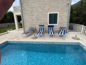 a group of chairs and a swimming pool at Villa Leen Dubrovnik in Ðurinići
