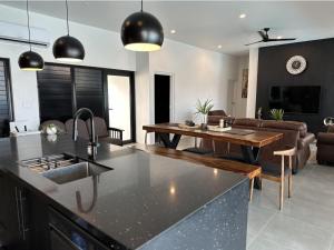 a kitchen and living room with a table and a couch at Bure 30 Luxury Villa in Nadi