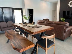 a living room with a wooden table and a couch at Bure 30 Luxury Villa in Nadi