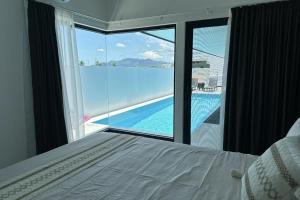 a bedroom with a bed and a view of a swimming pool at Bure 30 Luxury Villa in Nadi