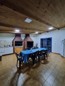 a large dining room with a blue table and chairs at Matices Hostel Centro in El Calafate