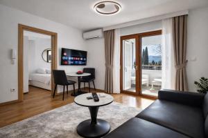 a living room with a couch and a table at Luxury Apartment-Aurora 33 Free Parking City Center in Podgorica