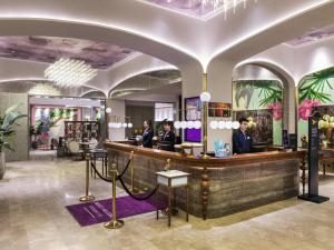 a lobby with three people sitting at a counter at Mercure Nanjing Downtown in Nanjing