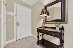 a room with a mirror and a table with a lamp at Where the Harbor Wakes For 6 in Destin