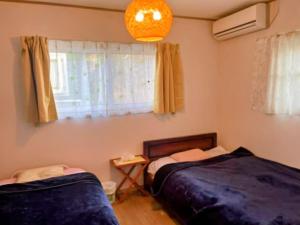 a bedroom with two beds and a window at Fuji Hike Stay in Oyama