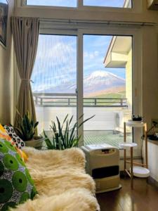 a bedroom with a large window with a view of a mountain at Fuji Hike Stay in Oyama