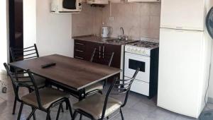 a kitchen with a table and chairs and a refrigerator at Gotas de Rocío - Balcón para 4 in San Antonio Oeste +3 photos