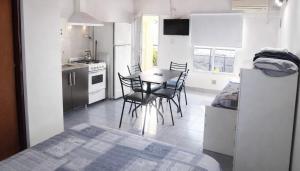 a kitchen and dining room with a table and chairs at Gotas de Rocío - Balcón para 4 in San Antonio Oeste
