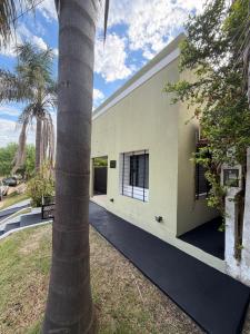 an exterior view of a house with a palm tree at Ana y Fran in Villa Zorraquín