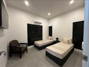 a hotel room with two beds and a chair at Bure 30 Luxury Villa in Nadi +30 photos