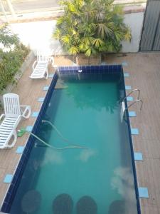 a pool with two chairs and a hose in the water at Passeio de quadriciclo com hospedagem in Guapimirim