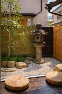 an asian garden with a stone fountain and rocks at 滋庵 jian okayama in Okayama