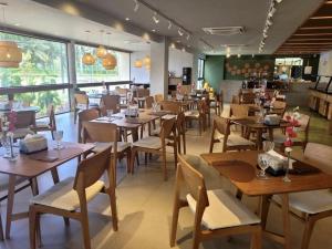 a dining room with wooden tables and chairs at Flat Malia Beach 005A in Porto De Galinhas