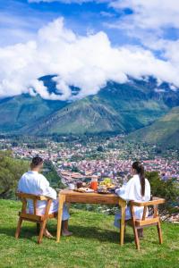 a man and woman sitting at a table on top of a mountain at Tara Vegan Lodge - Sacred Valley in Urubamba +105 photos