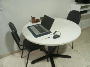 a white table with a laptop and a mouse on it at Studio 501 Campinas SP in Campinas