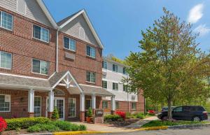 a brick building with a car parked in front of it at Extended Stay America Suites - Boston - Peabody in Peabody