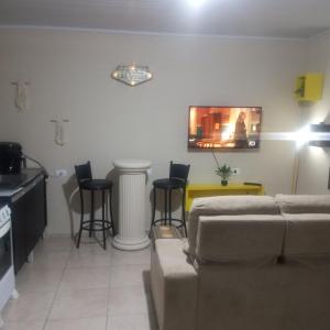 a living room with a couch and a table and chairs at Microcasa na região do lago in Cascavel