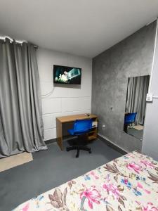 a bedroom with a desk and a bed and a tv at Lar Doce Lar Realizando Sono 4 !! in Arcos