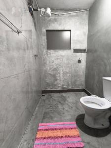 a bathroom with a toilet and a television on the wall at Lar Doce Lar Realizando Sono 4 !! in Arcos