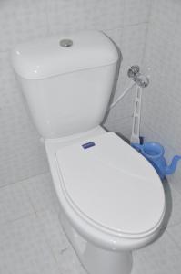 a white toilet in a bathroom with a toothbrush at Ayub Residence Bhurban in Murree