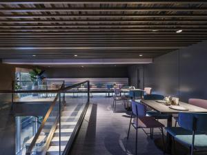 a restaurant with tables and chairs and a staircase at Mercure Nanjing Olympic EXPO in Nanjing