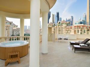 a hot tub on a balcony with a view of the city at Swissôtel Al Murooj Dubai in Dubai