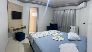 a bedroom with a blue bed with towels on it at Hotel CNP Brasil in Campo Novo do Parecis