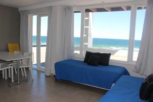 a bedroom with a blue bed and a view of the ocean at Bahia creek in Las Grutas