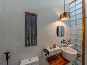 a bathroom with a sink and a toilet and a mirror at Marram Villas 2 Prime Location in Paje +13 photos