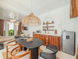 a kitchen with a table and chairs and a refrigerator at Marram Villas 2 Prime Location in Paje