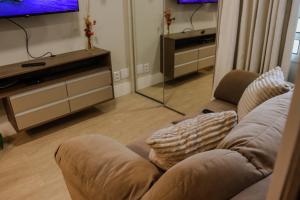 a living room with a couch and a flat screen tv at Studio no Sudoeste, vista da 1ª Avenida, tudo a pé in Brasília